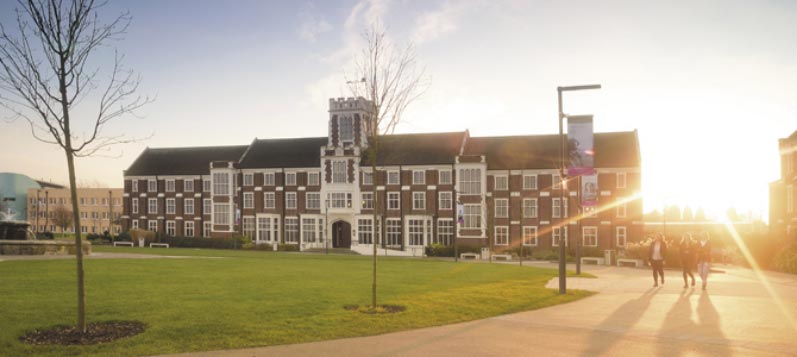 Loughborough university sunset with students walking in the distance.